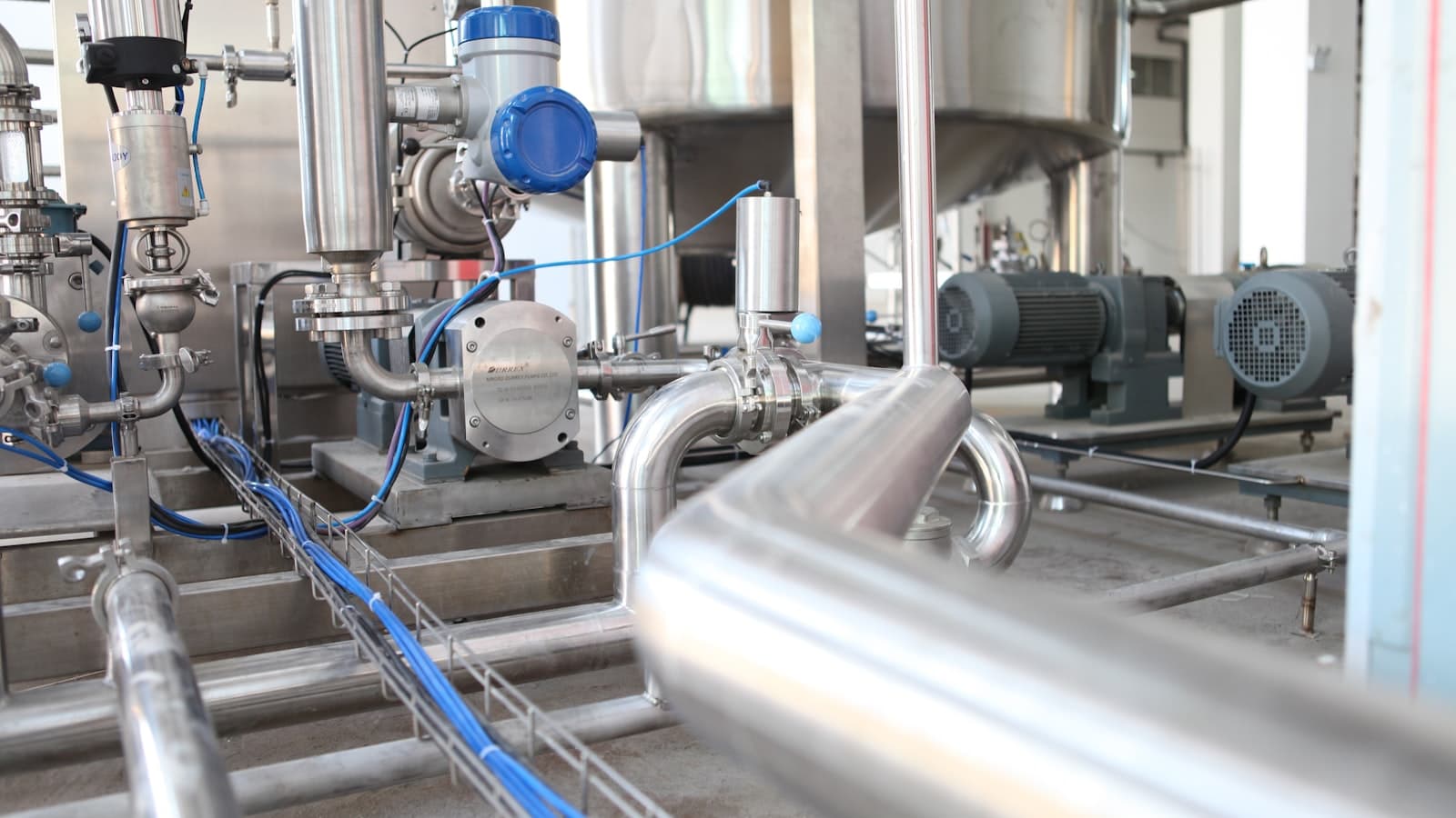 Process piping with an instrument transmitter, pumps, and signal cabling in a plant